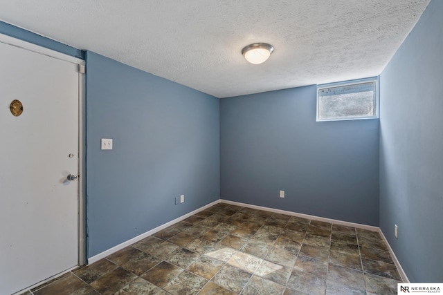 2725 Monroe St, Omaha, NE 68107 - spare room featuring baseboards, stone finish floor, and a textured ceiling