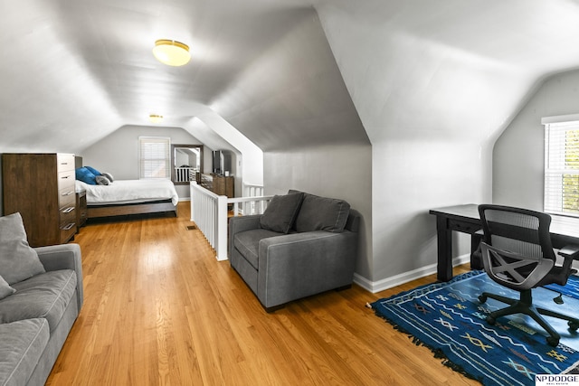 bedroom featuring light wood-style floors, baseboards, and vaulted ceiling