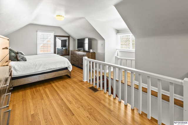 bedroom featuring lofted ceiling and light wood finished floors
