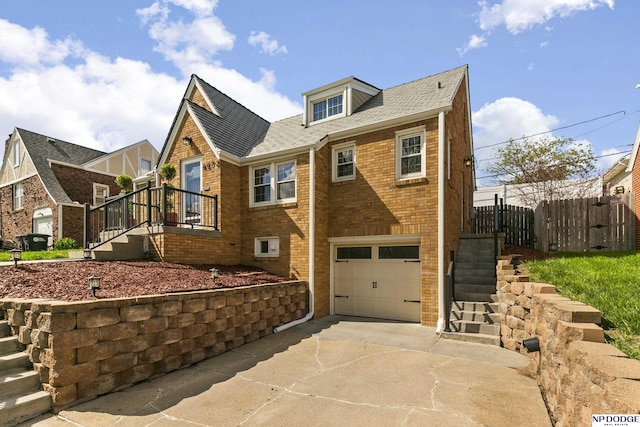 view of front of property featuring fence, brick siding, concrete driveway, an attached garage, and stairway