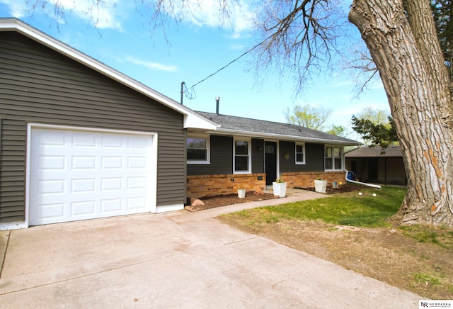 single story home featuring concrete driveway, roof with shingles, an attached garage, and brick siding