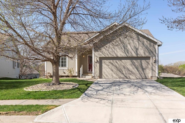 view of front of property with concrete driveway, a front yard, and a garage