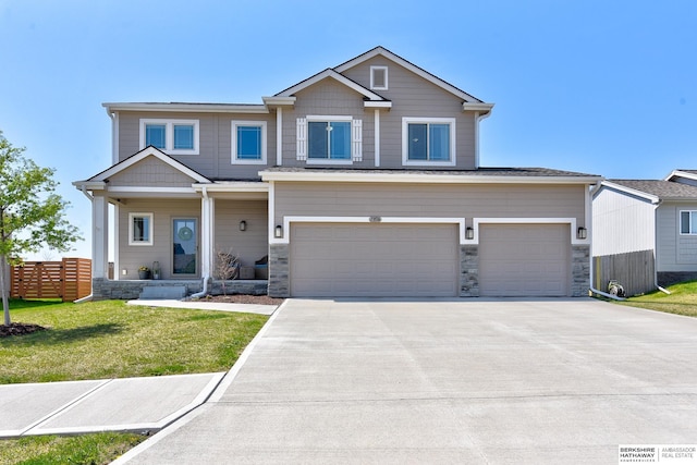 view of front facade with fence, concrete driveway, an attached garage, stone siding, and a front yard