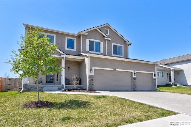 view of front of property with driveway, stone siding, fence, an attached garage, and a front yard