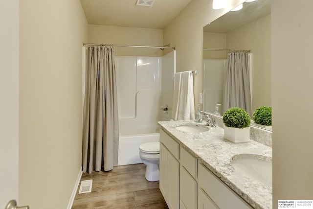 full bathroom with toilet, wood finished floors, a sink, and visible vents