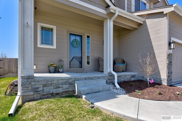 property entrance with a porch and fence