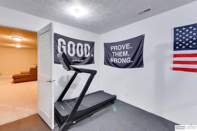 workout room with carpet flooring, a textured ceiling, and visible vents