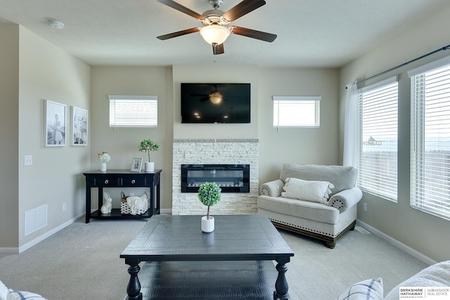 living room featuring ceiling fan, carpet floors, visible vents, and a fireplace