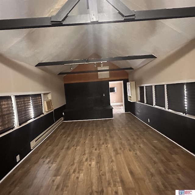 unfurnished living room with a baseboard heating unit, lofted ceiling with beams, baseboards, and wood finished floors