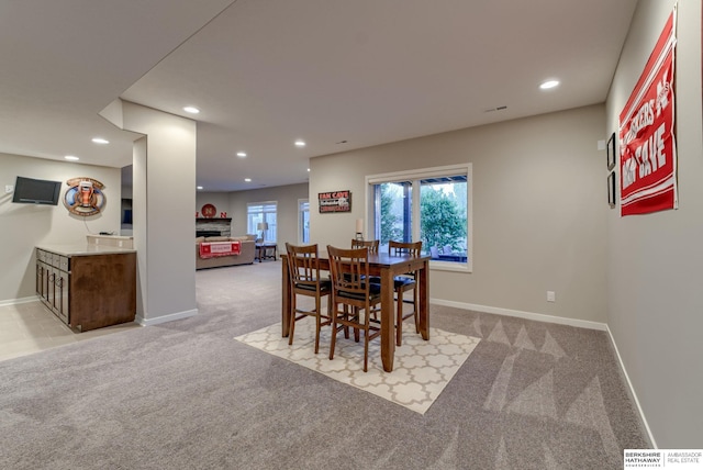 dining space with light colored carpet, a fireplace, baseboards, and recessed lighting