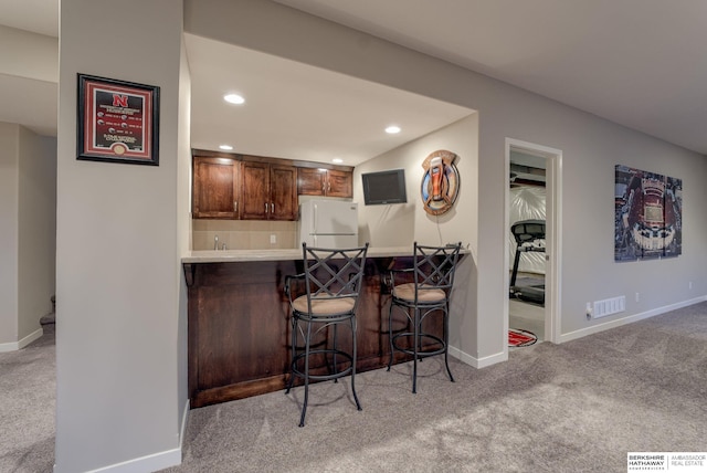 kitchen featuring carpet flooring, visible vents, baseboards, freestanding refrigerator, and recessed lighting