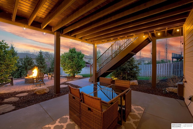 view of patio / terrace featuring a fire pit, stairway, and fence