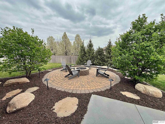 view of patio featuring a fire pit and fence