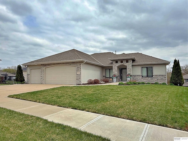 prairie-style house with concrete driveway, an attached garage, stucco siding, stone siding, and a front yard