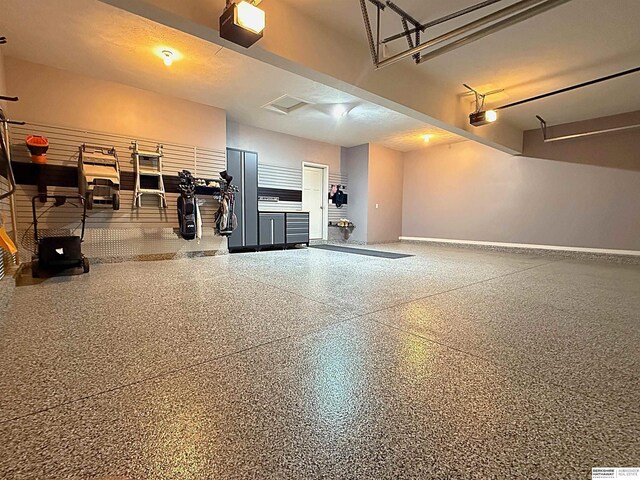 garage with baseboards and a garage door opener
