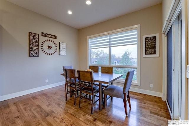 dining room with baseboards, wood finished floors, and recessed lighting