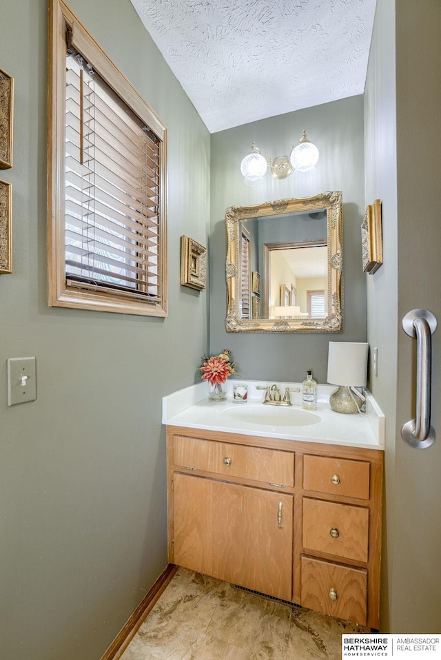 30238 Nixon Dr, Honey Creek, IA 51542 - bathroom featuring baseboards, vanity, and a textured ceiling
