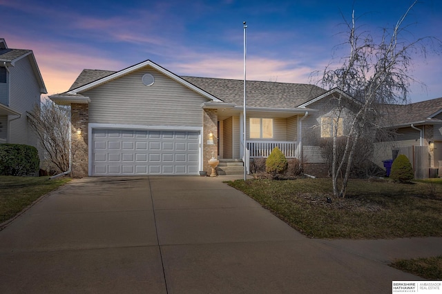 single story home with roof with shingles, driveway, covered porch, a garage, and brick siding