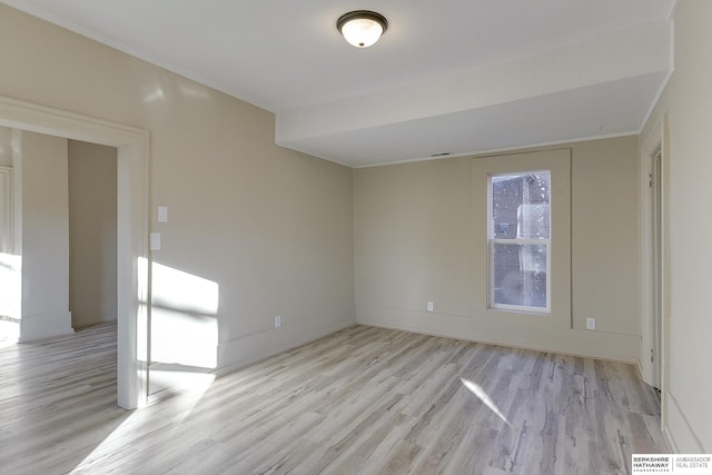 spare room with baseboards and light wood-style floors