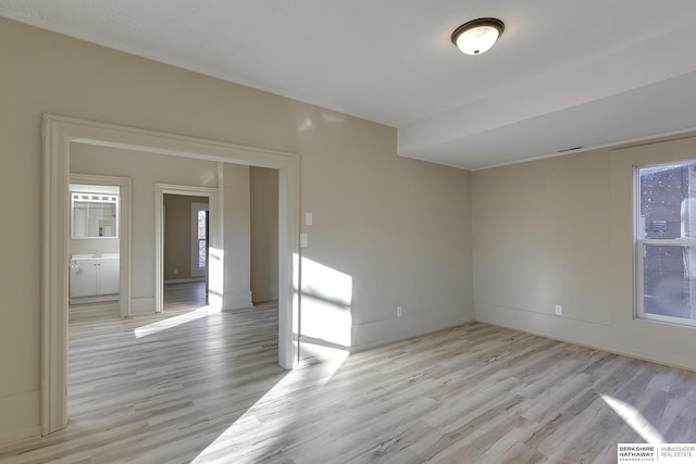 unfurnished room with baseboards, a healthy amount of sunlight, and light wood-style flooring