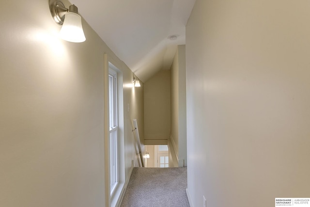 corridor with vaulted ceiling, carpet, and an upstairs landing
