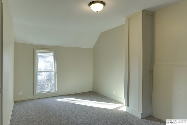 interior space featuring vaulted ceiling and baseboards