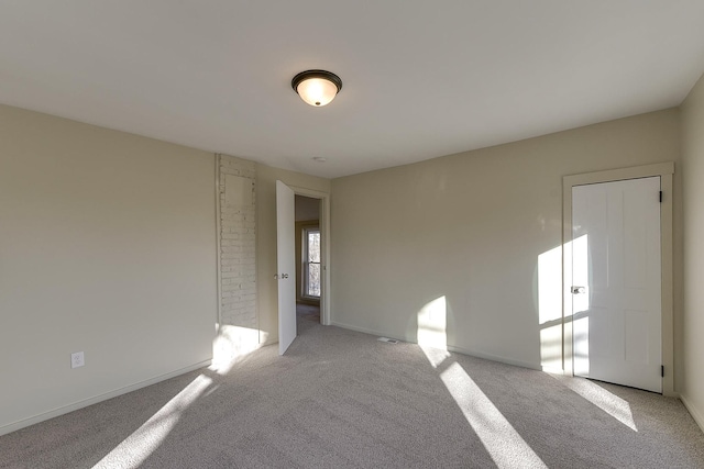 empty room with baseboards and light colored carpet