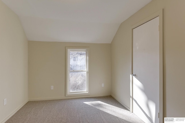 unfurnished bedroom featuring baseboards, vaulted ceiling, and carpet flooring