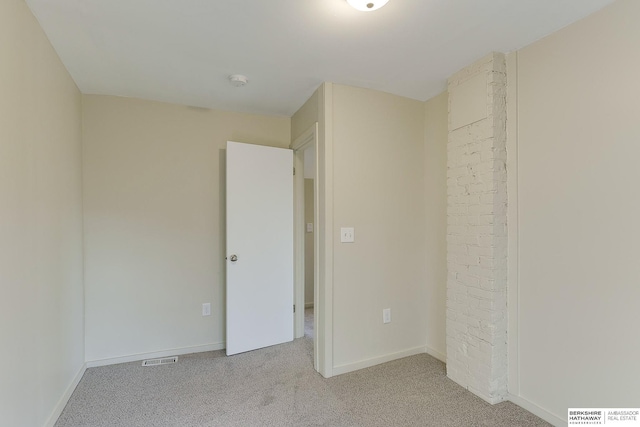 spare room featuring baseboards, visible vents, and light colored carpet