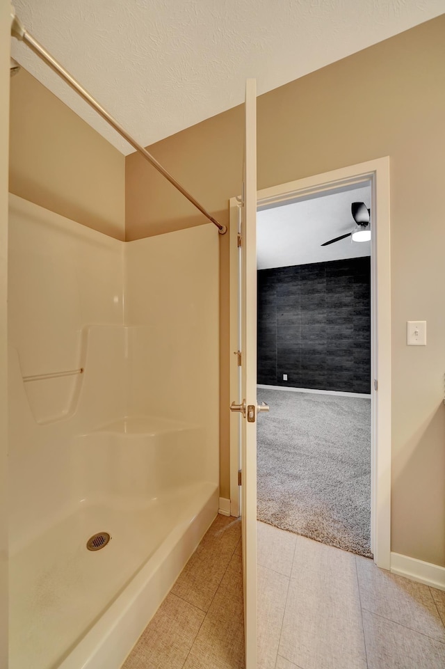 bathroom featuring walk in shower, baseboards, and tile patterned flooring