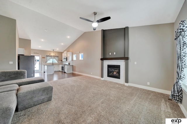 living room featuring lofted ceiling, carpet, a ceiling fan, baseboards, and a fireplace