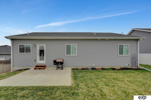 rear view of house with a lawn, fence, a patio, and entry steps