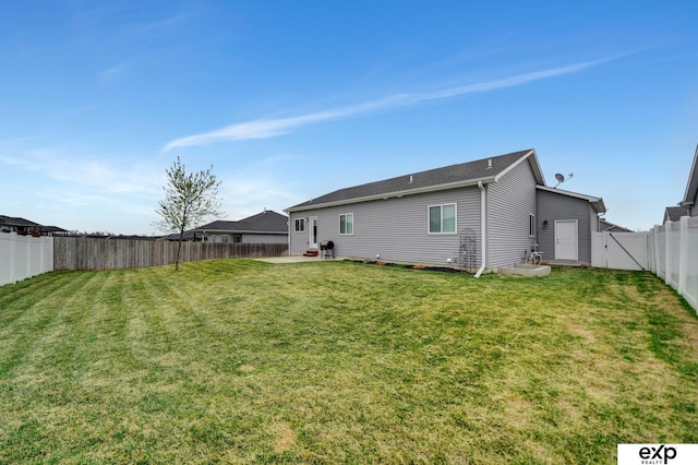 rear view of house featuring a fenced backyard and a lawn