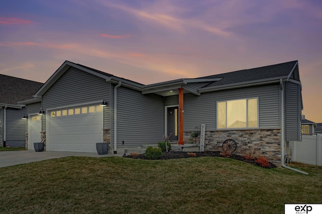 view of front of home with an attached garage, a front lawn, driveway, and stone siding