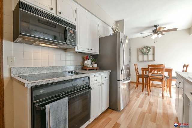 kitchen with white cabinets, light wood-style flooring, light countertops, and black appliances