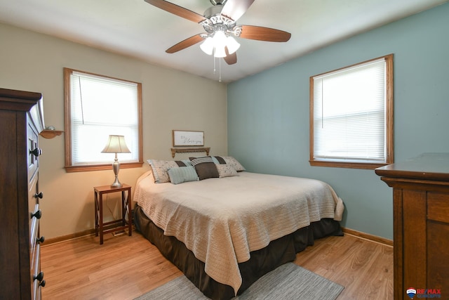 bedroom featuring light wood-type flooring, a ceiling fan, and baseboards