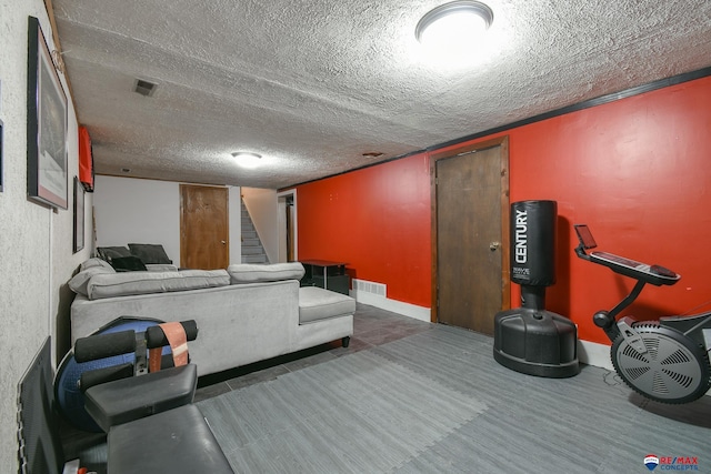 interior space with a textured ceiling, stairway, and visible vents