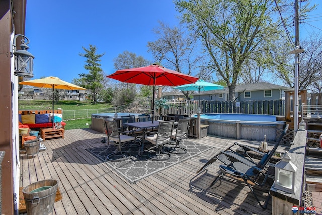 deck with a fenced in pool, outdoor dining space, and a fenced backyard