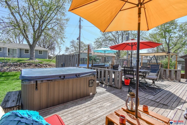 wooden deck with a hot tub, outdoor dining area, and fence