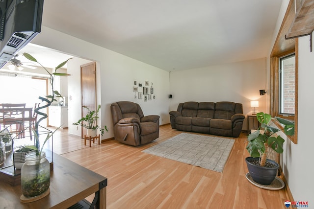 living area featuring ceiling fan, baseboards, and wood finished floors