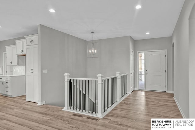 entrance foyer with recessed lighting, baseboards, an inviting chandelier, and light wood-type flooring