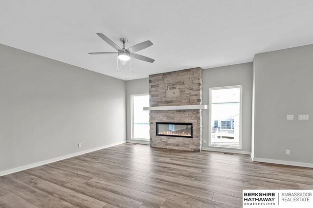 unfurnished living room with baseboards, a ceiling fan, and wood finished floors