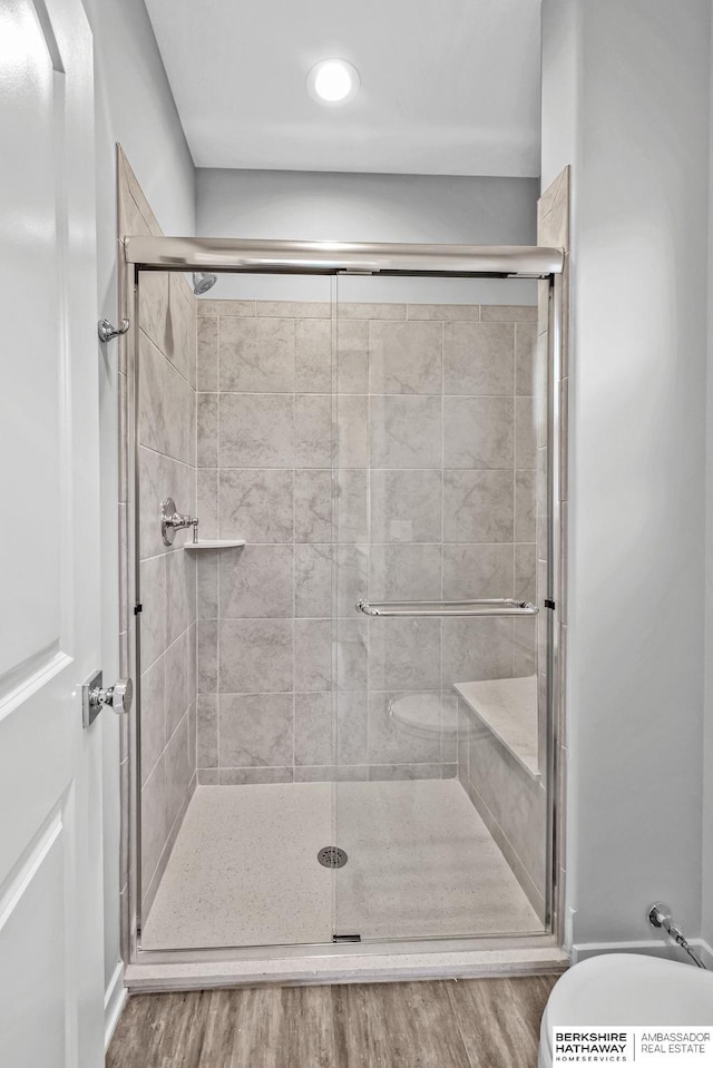 full bathroom with wood finished floors, recessed lighting, and a shower stall