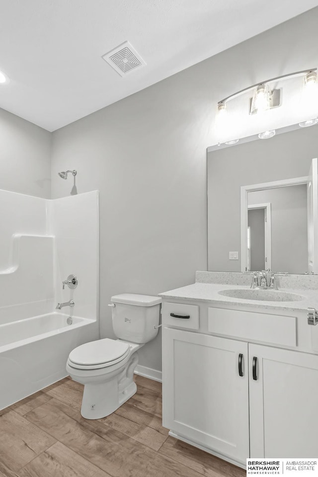full bath featuring wood finished floors, vanity, shower / tub combination, toilet, and visible vents