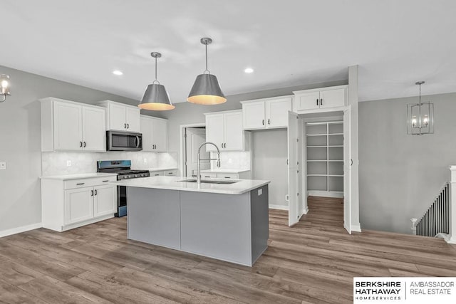 kitchen featuring a chandelier, backsplash, stainless steel appliances, and a sink
