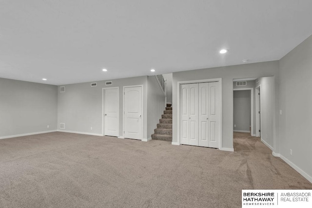 finished below grade area featuring baseboards, recessed lighting, visible vents, carpet, and stairs