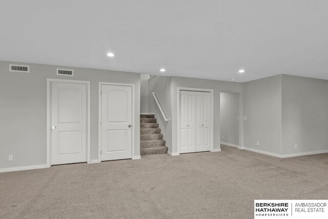 below grade area with stairway, visible vents, and carpet flooring