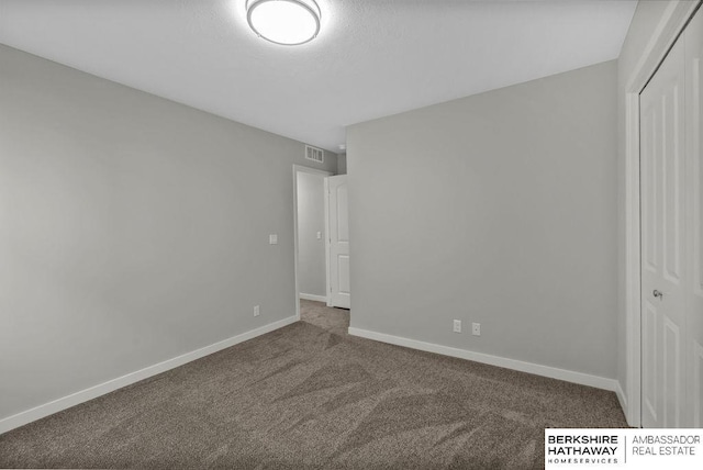 unfurnished bedroom with carpet, visible vents, a closet, baseboards, and a textured ceiling