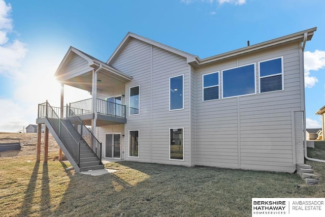 back of property with stairway, a yard, and a deck