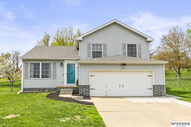 split level home with fence, driveway, roof with shingles, and a front yard